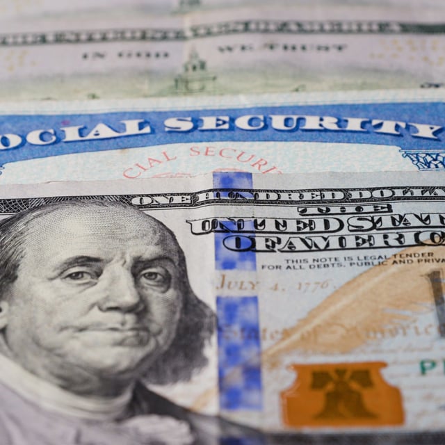 A stock image of a Social Security card and U.S. dollars. Payments are made monthly to all recipients.