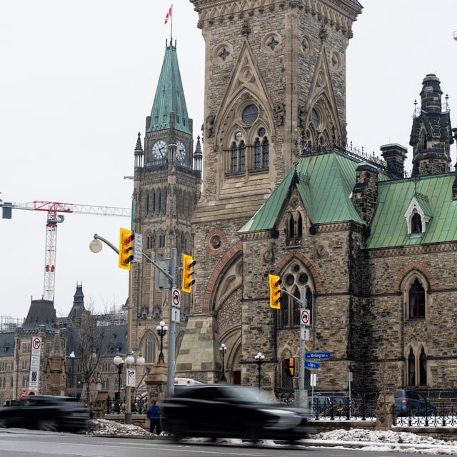 Vehicles make their way along Wellington St., in front of Parliament Hill in Ottawa, Monday, Dec. 16, 2024. THE CANADIAN PRESS/Spencer Colby