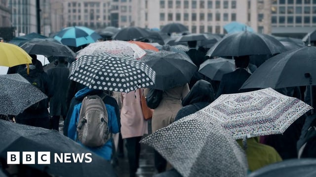 People commuting with umbrellas