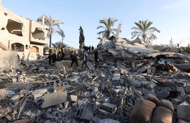 Palestinians inspect the damage at the site of an Israeli strike on a house, amid the Israel-Hamas conflict, in Deir Al-Balah, in the central Gaza Strip, December 22, 2024.