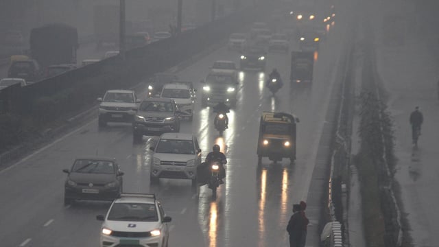 Vehicles ply on Delhi-Gurugram Expressway during rain on a cold winter day, in Gurugram on Friday. 