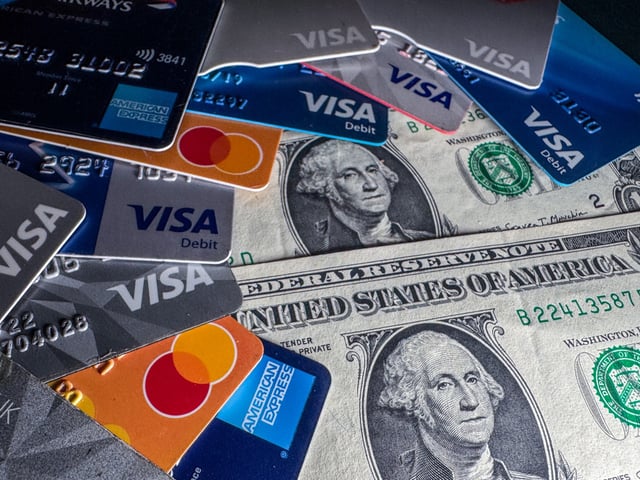 BATH, UNITED KINGDOM - DECEMBER 22: In this photo illustration the Visa, Mastercard and American Express logo on various credit cards and debit cards are seen beside US one dollar bills on December 22, 2024 in Somerset, England. A recent Senate hearing heard of the large profits companies such as Mastercard and Visa were making while the US grapples with a record amount of credit card debt. (Photo by Anna Barclay/Getty Images)