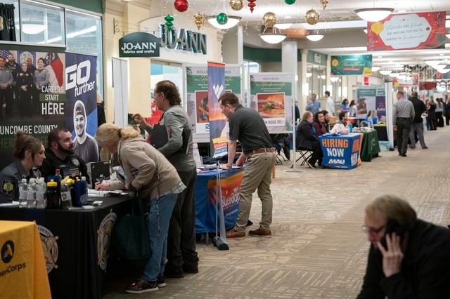 Hiring representatives speak with jobseekers at a job and resource fair hosted by the Mountain Area Workforce Development Board in partnership with NCWorks in Hendersonville, North Carolina, on November 19, 2024.