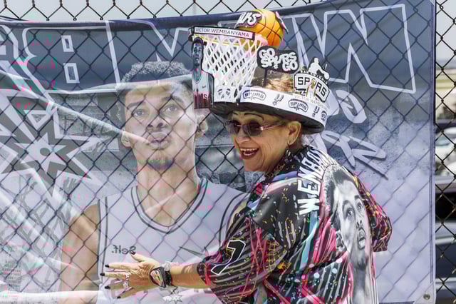 Spurs superfan Sovia Lauriano embraces a flag featuring a picture of Victor Wembanyama as she waits for him to arrive in San Antonio outside of Signature North on June 23, 2023.