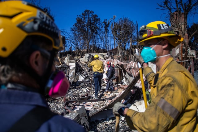 Fire Fighters inspect a burned out house in the Pacific Palisades on Jan. 16, 2025 in Los Angeles.