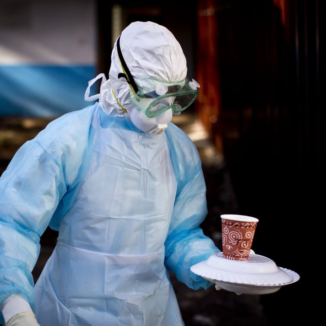 A medical worker carries a meal to an isolation tent housing a man being quarantined after coming into contact with a carrier of the Marburg Virus, at the Kenyatta National Hospital in Nairobi, Kenya, October 8, 2014. Tanzania’s president said that one sample from a remote part of northern Tanzania tested positive for the disease,