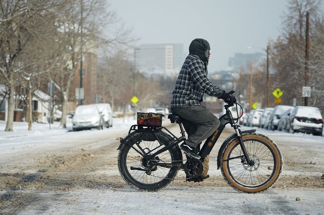 A cyclist navigates 13th Avenue after a winter storm plunged daytime high temperatures into the single digits and left up to six inches of snow in its wake Monday in Denver.