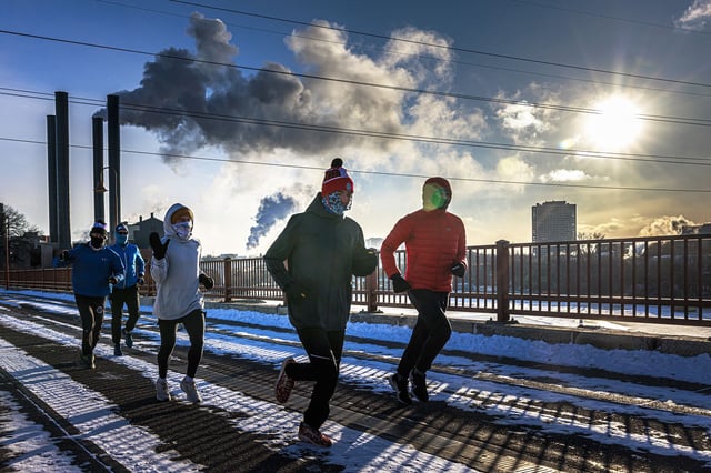 Runners brave the extreme cold as they cross the Stone Arch Bridge over the frozen Mississippi River during Arctic Blast in Minneapolis, Minnesota, on January 20, 2025. The air temperature was -18°F (-27.8°C), with a wind chill making it feel like -29°F (-34°C). (Photo by Kerem YUCEL / AFP) (Photo by KEREM YUCEL/AFP via Getty Images)
