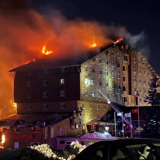 Firefighters work to extinguish a fire in a hotel at a ski resort of Kartalkaya in Bolu province, in northwest Turkey, Tuesday, Jan. 21, 2025. (IHA via AP)
