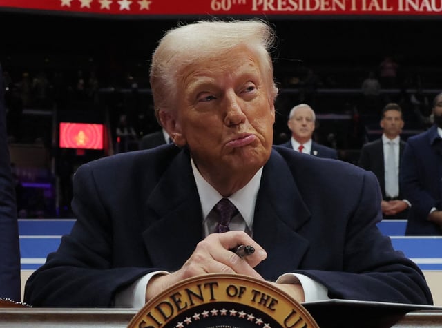 U.S. President Donald Trump reacts as he signs an executive order during the inaugural parade inside Capital One Arena on the inauguration day of his second presidential term, in Washington, U.S. January 20, 2025.