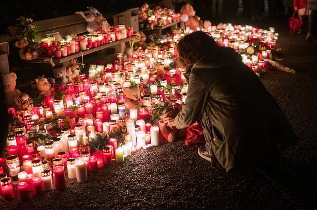 Eine Person legt nach der tödlichen Messerattacke im Park Schöntal in Aschaffenburg einen Teddybären bei einer Gedenkstätte nieder.
