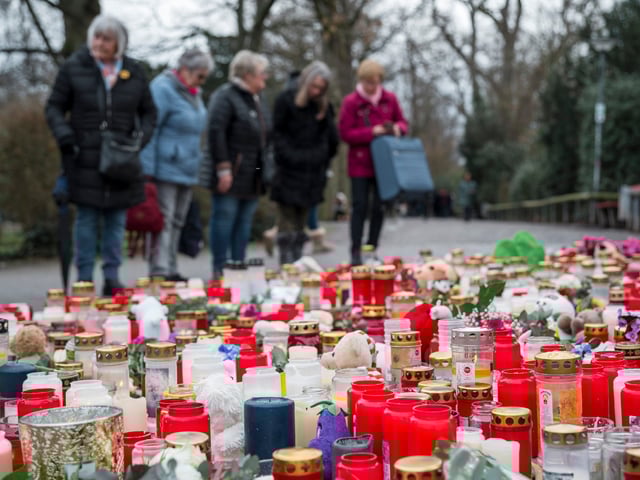 Aschaffenburg: Im Gedenken an die tödliche Messerattacke im Park Schöntal stehen Menschen hinter zahlreichen Kerzen.