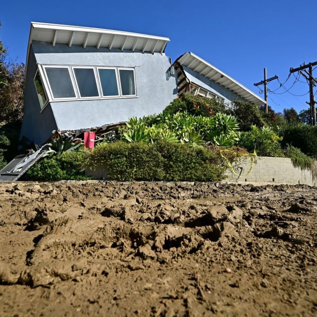 A house unscathed by the Palisades fire is seen split in half by a landslide in the Pacific Palisades neighborhood of Los Angeles, California, on January 16, 2025.