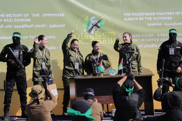 Israeli female soldier hostages wave at a Palestinian crowd before being handed over to the Red Cross in Gaza City, on Saturday.