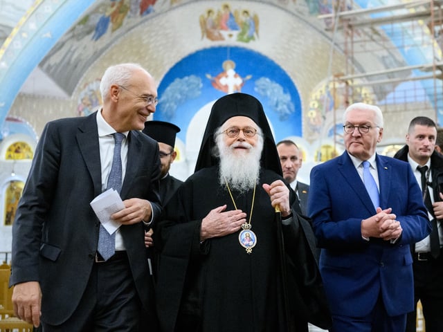 01 December 2022, Albania, Tirana: Federal President Frank-Walter Steinmeier (r), Peter Zingraf (l), Ambassador of the Federal Republic of Germany to Albania, and Anastasios Yannoulatos, Archbishop of Tirana, Durres and all of Albania, meet for talks in the Orthodox cathedral. President Steinmeier visits the countries of Northern Macedonia and Albania during his four-day trip to the Balkans. Photo: Bernd von Jutrczenka/dpa (Photo by Bernd von Jutrczenka/picture alliance via Getty Images)