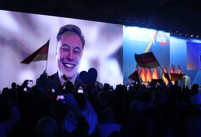 HALLE, GERMANY - JANUARY 25: Tech billionaire Elon Musk speaks live via a video transmission during a speech by Alice Weidel, chancellor candidate of the far-right Alternative for Germany (AfD) political party, at the AfD election campaign launch rally on January 25, 2025 in Halle, Germany. Musk is an outspoken supporter of the AfD and is urging German voters to cast their ballots for the party. The AfD is currently in second place in polls ahead of federal parliamentary snap elections scheduled for February 23. (Photo by Sean Gallup/Getty Images)