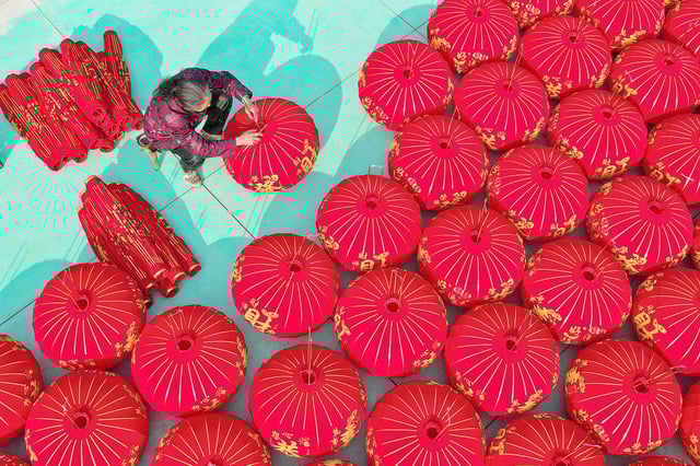 NANJING, CHINA - JANUARY 21: Aerial view of a worker arranging red lanterns to dry at a workshop in preparation for the upcoming Spring Festival on January 21, 2025 in Nanjing, Jiangsu Province of China. (Photo by Zhou Qiang/VCG via Getty Images)