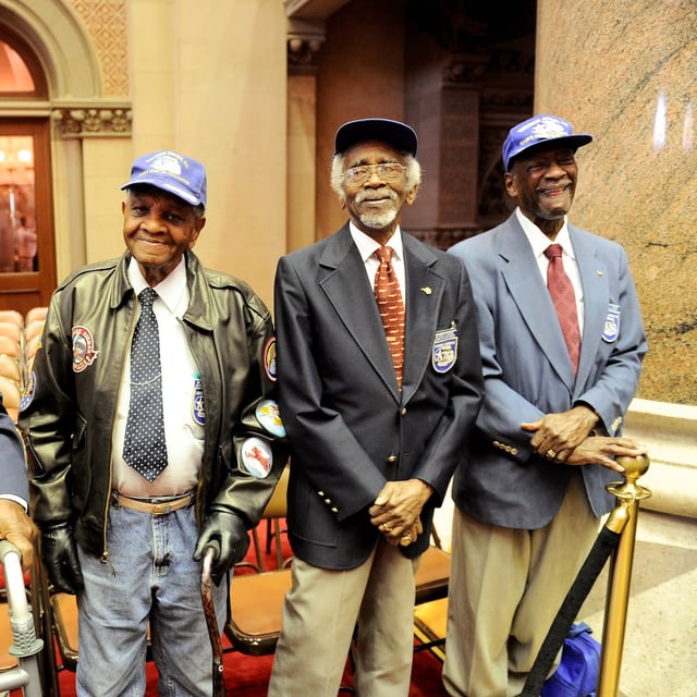 FILE - Tuskegee Airmen, from left, Audley Coulthurst of New York, William Johnson of Glen Cove, N.Y., Wilfred R. DeFour of New York, and Herbert C. Thorpe of Rome, N.Y., are honored by members of the New York Assembly upon their 75th Anniversary of the 332nd Fighter Group of the U.S. Army Air Corps during a recognition ceremony in the Assembly Chamber at the state Capitol, June 16, 2016, in Albany, N.Y. (AP Photo/Hans Pennink, File)