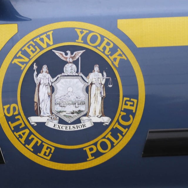 A New York State Police logo is shown on a state police officer's car near Dannemora, N.Y., Friday, June 12, 2015. A New York state trooper who claimed he was shot and wounded by an unknown gunman on a Long Island highway last year is facing criminal charges.
