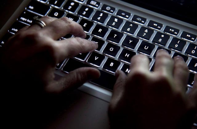 A woman uses her computer keyboard to type while surfing the internet in North Vancouver, B.C., on Wednesday, December, 19, 2012. 