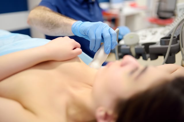 Un médecin pratique un examen à l’aide d’ultrasons sur une patiente.