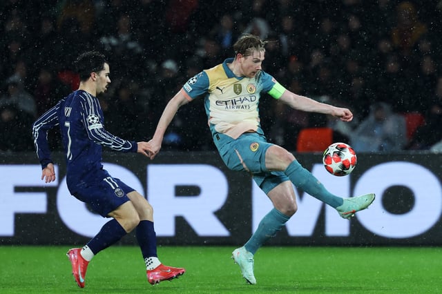 Manchester City midfielder #17 Kevin De Bruyne (R) controlled the ball next to Paris Saint-Germain midfielder #17 Vitinha during a UEFA Champions League match.