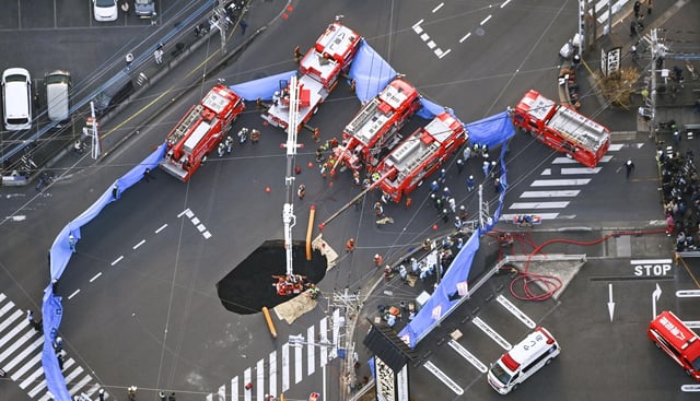 An aerial view shows rescue operations underway at a large sinkhole that swallowed a truck at an intersection in Yashio, north of Tokyo, Japan Jan. 28, 2025, in this photo taken by Kyodo.
