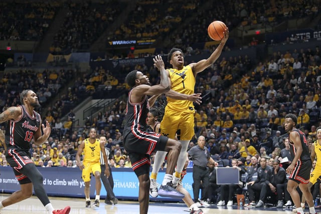 West Virginia guard Joseph Yesufu (1) is defended by Houston guard Terrance Arceneaux (23) during the first half of an NCAA college basketball game Wednesday, Jan. 29, 2025, in Morgantown, W.Va. (AP Photo/Kathleen Batten)