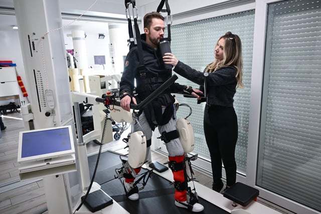 Mike Glemser, unterstützt von seiner Freundin Lara Lindmayer, bei einer Übungseinheit einer robotergestützten Gangtherapie