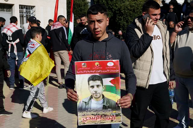 A Palestinian child in Ramallah holds a portrait of Zakaria Zubeidi, who was released from Israeli prison on Thursday.
