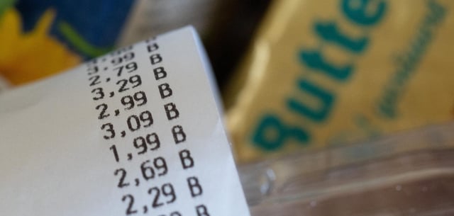 Kassenzettel auf Einkaufsliste mit Lebensmitteln. Die Verbraucherpreise steigen weniger stark