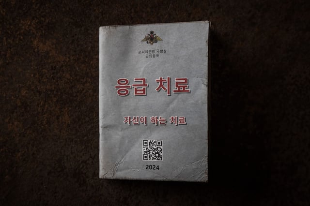 The cover from a first aid manual titled "Ministry of Defence of the Russian Federation, Emergency Medical Treatment (First Aid), Self-administered first aid (QR code)/ 2024," found on a North Korean soldier in the Kursk Region, photographed at a Ukrainian military base.