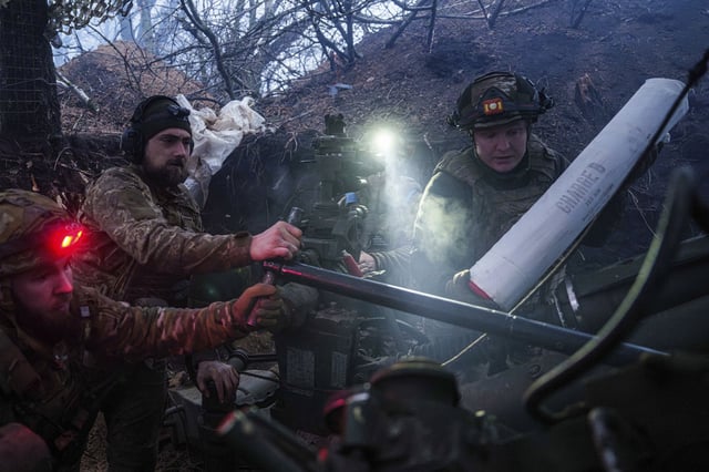 Ukrainian servicemen of 148th artillery brigade load ammunition into a M777 howitzer before firing towards Russian positions at the frontline on Velyka Novosilka direction, Donetsk region, Ukraine, Jan. 26, 2025. (AP Photo/Evgeniy Maloletka)