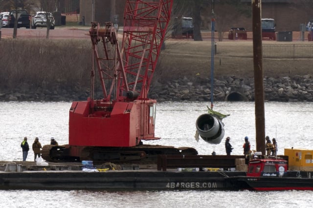 Rescue and salvage crews pull up a plane engine as cranes work near the wreckage of an American Airlines jet in the Potomac River from Ronald Reagan Washington National Airport, Monday, Feb. 3, 2025, in Arlington, Va. (AP Photo/Jose Luis Magana)