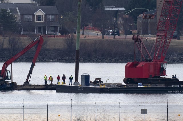 Rescue and salvage crews with cranes work near the wreckage of an American Airlines jet in the Potomac River from Ronald Reagan Washington National Airport, Monday, Feb. 3, 2025, in Arlington, Va. (AP Photo/Jose Luis Magana)