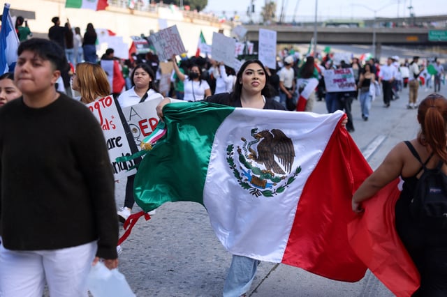 A protester holds a Mexican flag as they block the Santa Ana Freeway during a demonstration in support of immigrants in Los Angeles, California, on Feb. 2, 2025.