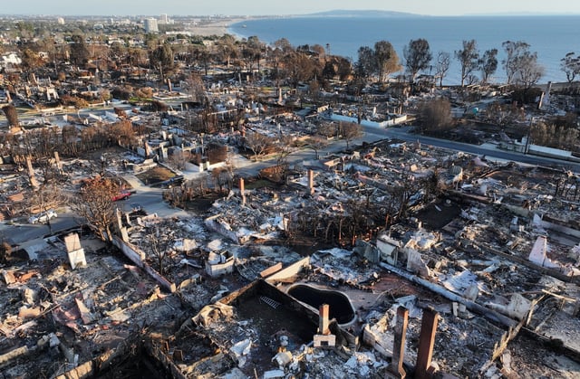An aerial view of homes destroyed in the Palisades Fire with the Pacific Ocean in the distance on January 27, 2025 in Pacific Palisades, California.