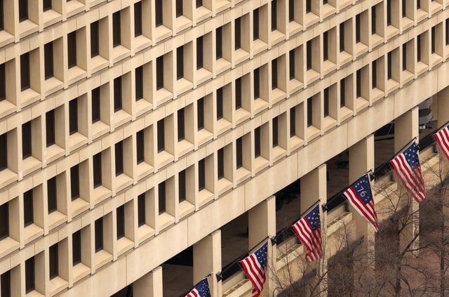 Flags fly beneath office windows at the FBI headquarters, days after the Trump administration launched a sweeping round of cuts at the Justice Department, in Washington, U.S., February 3, 2025. REUTERS/Kevin Lamarque