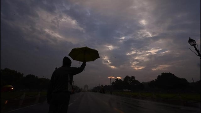 A person opens the umbrella during morning walk at Kartavya Path in New Delhi on Tuesday. (Arvind Yadav/ HT Photo)