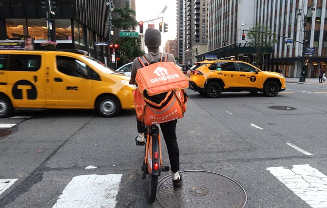 NEW YORK, NY - JUNE 13: A delivery person for GrubHub rides an e-bike along Third Avenue on June 13, 2024, in New York City. (Photo by Gary Hershorn/Getty Images)