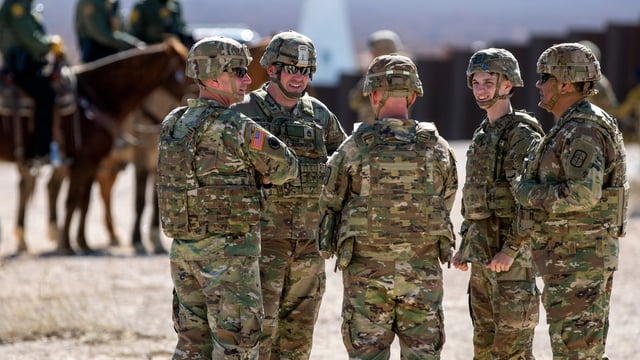 Army soldiers chat while waiting the arrival of Defense Secretary Pete Hegseth to the US-Mexico border in Sunland Park, N.M., Monday, Feb. 3, 2025. (AP Photo/Andres Leighton)