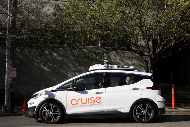 A woman smiles in the back seat of a self-driving Chevy Bolt EV car during a media event by Cruise, GM’s autonomous car unit,  in San Francisco, California, U.S. November 28, 2017. REUTERS/Elijah Nouvelage/File Photo