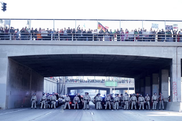 CORRECTS NAME OF THE FREEWAY - Law enforcement personnel stage in front of a group of demonstrators who shut down the 101 freeway during a protest calling for immigration reform Sunday, Feb. 2, 2025, in Los Angeles. (AP Photo/Eric Thayer)