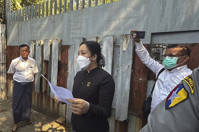 An unidentified legal official from Kamayut district court speaks outside the residence of ousted leader Aung San Suu Kyi as the home is auctioned in Yangon, Myanmar, Wednesday, Feb. 5, 2025. (AP Photo/Thein Zaw)