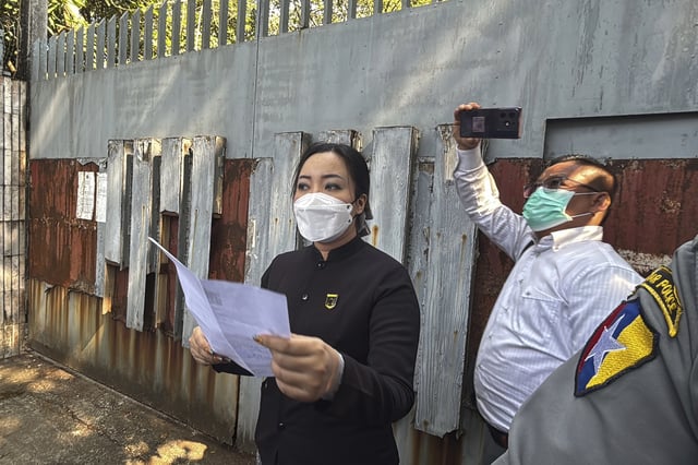 An unidentified legal official from Kamayut district court speaks outside the residence of ousted leader Aung San Suu Kyi as the home is auctioned in Yangon, Myanmar, Wednesday, Feb. 5, 2025. (AP Photo/Thein Zaw)