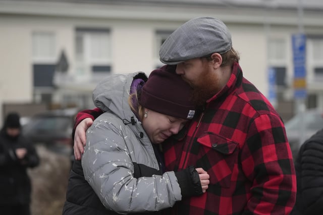 People gather at a makeshift memorial near the scene of a shooting on the outskirts of Orebro, Sweden, Wednesday, Feb. 5, 2025. (AP Photo/Sergei Grits)