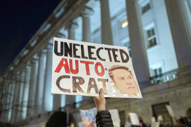 People protest during a rally against Elon Musk outside the Treasury Department in Washington, Tuesday, Feb. 4, 2025. (AP Photo/Jose Luis Magana)