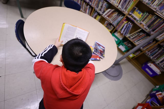 A student in the library reads a book at Yung Wing School P.S. 124 on February 2, 2022 in New York City.