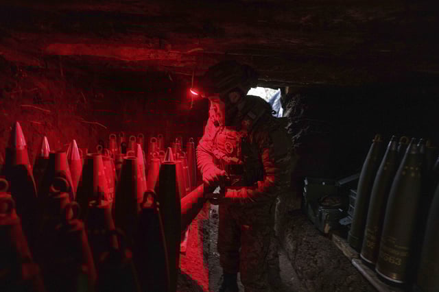 A Ukrainian serviceman of the 148th artillery brigade prepares 155mm artillery shells for a M777 howitzer before firing towards Russian positions at the frontline on Velyka Novosilka direction, Donetsk region, Ukraine, Jan. 26, 2025. (AP Photo/Evgeniy Maloletka)