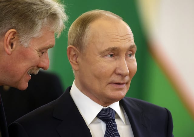 Russian President Vladimir Putin (R) listens to Kremlin spokesperson Dmitry Peskov (L) during a summit on October 8, 2024, in Moscow, Russia.